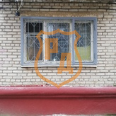 распашная решетка серого цвета на окно первого этажа